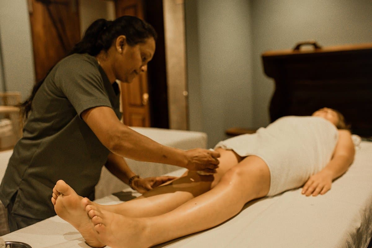 A therapist performing a gentle soothing massage with warm herbal oils